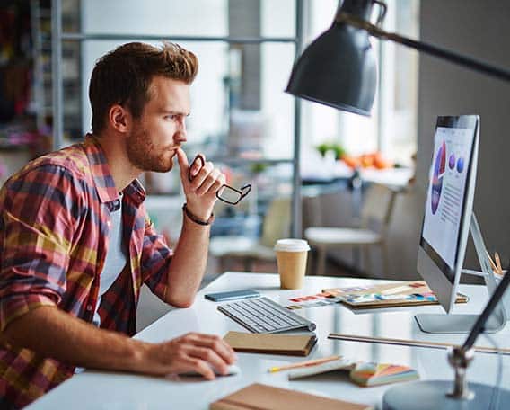 Homme réfléchis devant graphique sur l'ordinateur