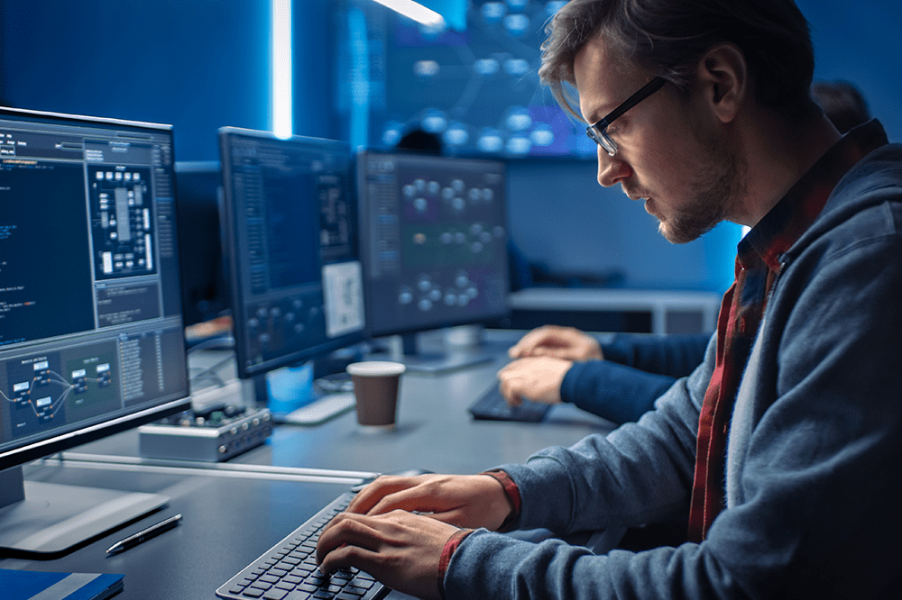 Homme devant un écran entrain de faire du code